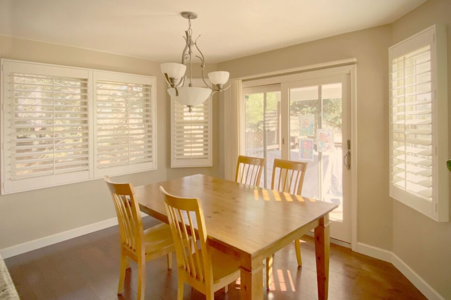 Custom shutters enhancing natural light in scenic home dining areas.