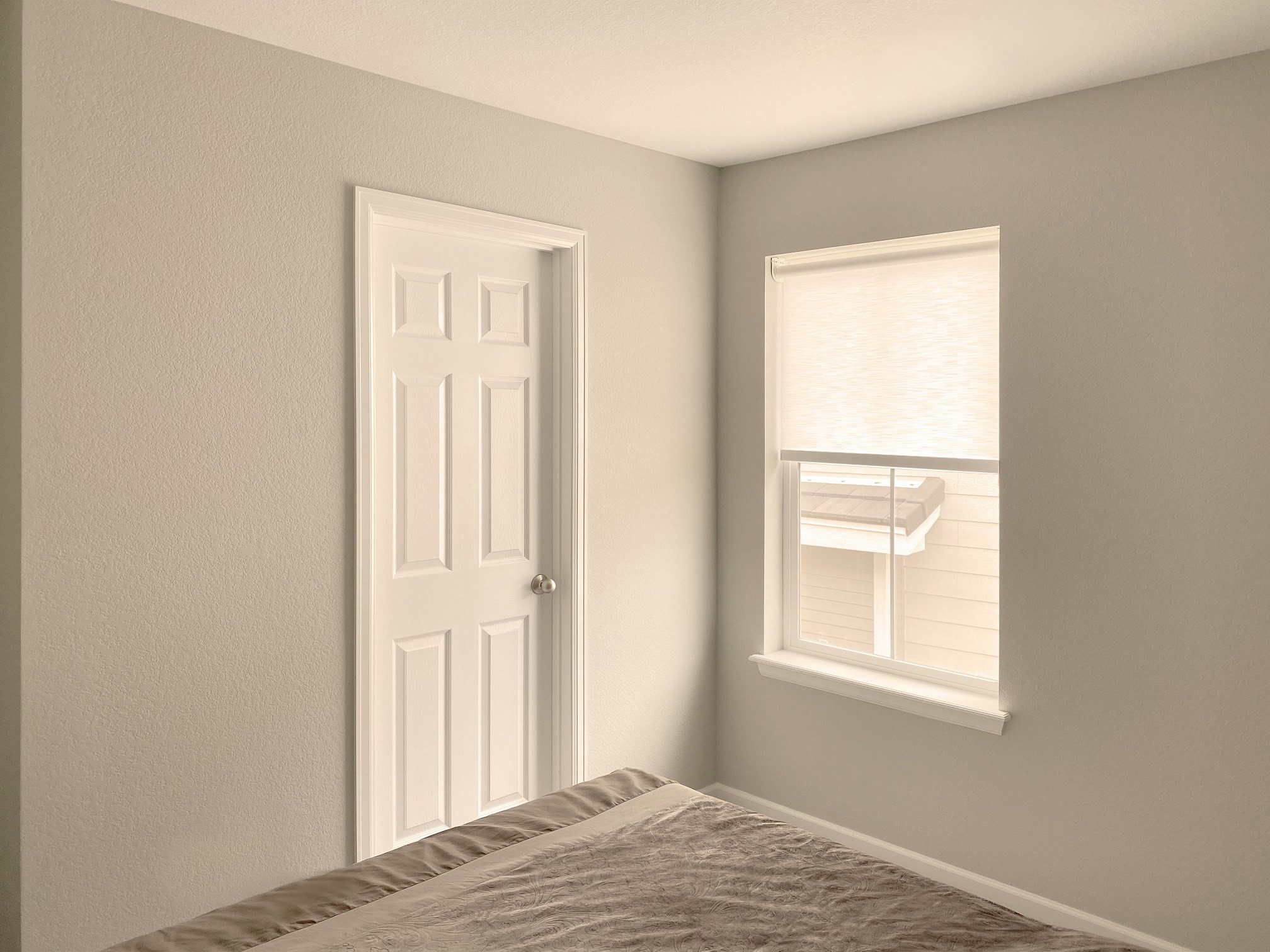 Bedroom with a custom designer roller window shades.